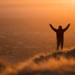 Una persona che si prepara a incrementare motivazione con positività guardando l'alba.
