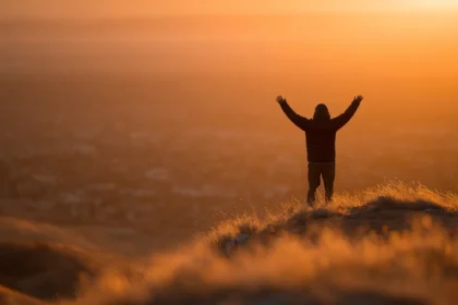 Una persona che si prepara a incrementare motivazione con positività guardando l'alba.